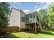 Exterior view of a home featuring a deck, sunroom, well-maintained lawn, and partial fencing at 2613 Sweet Gum Dr, Hillsborough, NC 27278