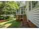 Exterior view of the home's sunroom addition, with wood stairs leading down to the yard at 2613 Sweet Gum Dr, Hillsborough, NC 27278