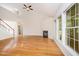 Large living room with fireplace, hardwood floors, fan and many windows at 2613 Sweet Gum Dr, Hillsborough, NC 27278