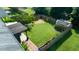 Aerial view of backyard with a privacy fence, lush lawn, and custom greenhouse at 326 Slate Dr, Gibsonville, NC 27249