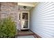 Welcoming front door with a 'Hello Summer' sign and brick accents at 326 Slate Dr, Gibsonville, NC 27249