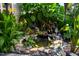 Backyard pond surrounded by rocks, flowers, and lush plants, creating a serene outdoor oasis at 326 Slate Dr, Gibsonville, NC 27249
