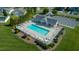 Aerial view of a community pool with a modern pool house and plenty of lounge chairs for relaxing at 326 Slate Dr, Gibsonville, NC 27249