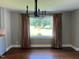 Inviting dining room with hardwood floors, modern chandelier, and large window with view at 331 E Lillington St, Angier, NC 27501