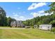 Charming home featuring red shutters, a well-manicured lawn, and auxiliary storage buildings at 3573 Northern Estates Cir, Rocky Mount, NC 27804