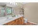 Bathroom with double sink vanity, large mirror, and decorative shelving for storage at 3806 Stoneybrook Dr, Durham, NC 27705