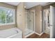 Bright bathroom featuring a soaking tub, glass-enclosed shower, and modern fixtures at 3806 Stoneybrook Dr, Durham, NC 27705