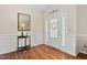 Bright foyer featuring hardwood floors, wainscoting, and a decorative mirror above a wooden table at 3806 Stoneybrook Dr, Durham, NC 27705