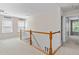 Bright hallway with wood railing, neutral carpet, and natural light streaming through the windows at 3806 Stoneybrook Dr, Durham, NC 27705