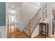 View of hallway and carpeted staircase with wood banister and table with lamp at 3806 Stoneybrook Dr, Durham, NC 27705