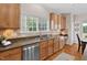 The kitchen features wood cabinets, stainless steel appliances, and granite countertops with a sink overlooking the backyard at 3806 Stoneybrook Dr, Durham, NC 27705