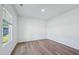 A bright, empty bedroom with wood-look flooring and a large window at 3813 Rosebush Dr, Zebulon, NC 27597