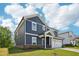 Side view of a navy two-story home with white trim, a two-car garage and a manicured lawn at 3813 Rosebush Dr, Zebulon, NC 27597