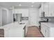 Modern kitchen boasts stainless appliances, quartz counters, white cabinetry and wood floors at 3813 Rosebush Dr, Zebulon, NC 27597
