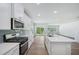 Open kitchen with stainless steel appliances and a kitchen island overlooks the spacious living area at 3813 Rosebush Dr, Zebulon, NC 27597