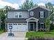 Charming two-story home with a well-manicured lawn, attached garage, and neutral-toned siding at 3845 Rosebush Dr, Zebulon, NC 27597
