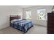 Cozy bedroom with plush carpet, a bed with a patterned comforter and multiple windows for plenty of natural light at 479 Clark Creek Ln, Cary, NC 27519