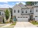Two-story townhome with a two-car garage, manicured lawn, and teal front door at 479 Clark Creek Ln, Cary, NC 27519