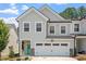 Charming townhome featuring a two-car garage, teal front door, and gray siding at 479 Clark Creek Ln, Cary, NC 27519