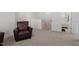Spacious living room with a comfortable leather armchair and neutral carpet and access to the bathroom at 479 Clark Creek Ln, Cary, NC 27519