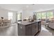 Open concept living space featuring a kitchen island, dining space, and living area with lots of light at 479 Clark Creek Ln, Cary, NC 27519