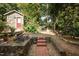 Lush backyard with mature trees, brick pathways, stone walls and garden area at 513 Cutler St, Raleigh, NC 27603