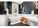 Stylish bathroom with a freestanding tub, dark blue walls, and a sleek pedestal sink at 513 Cutler St, Raleigh, NC 27603