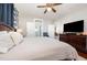 Bright bedroom with hardwood floors, TV, ensuite bathroom, and comfortable white bedding at 513 Cutler St, Raleigh, NC 27603