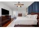 Spacious bedroom with dark wood furniture, a ceiling fan, and a plush king size bed at 513 Cutler St, Raleigh, NC 27603