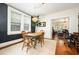 Sunny dining area with a wooden table, modern lighting, and a view to the living room at 513 Cutler St, Raleigh, NC 27603