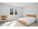 Sunlit bedroom with a modern bed frame, desk, and chair, offering a minimalist and inviting space at 5148 Glen Creek Trl, Garner, NC 27529