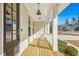 Inviting front porch with wooden floors, white columns, and views of the surrounding neighborhood at 5148 Glen Creek Trl, Garner, NC 27529