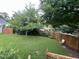 Backyard with green grass, mature trees, and a wooden fence at 526 Cardena School Rd, Fuquay Varina, NC 27526