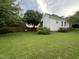 View of the backyard, featuring manicured lawn, trees, and the home's exterior at 526 Cardena School Rd, Fuquay Varina, NC 27526
