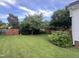 Large backyard showcasing lush green grass, mature trees, and a wooden fence at 526 Cardena School Rd, Fuquay Varina, NC 27526