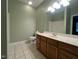Bathroom showcases a vanity with wooden cabinets, a sink, a large mirror, and a toilet against a green wall at 526 Cardena School Rd, Fuquay Varina, NC 27526