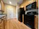 View of the kitchen with black appliances and complementing hardwood floors and cabinets at 526 Cardena School Rd, Fuquay Varina, NC 27526