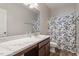 Bathroom with vinyl floor, modern vanity, and shower with blue and white curtain at 534 Lionheart Ln, Sanford, NC 27330
