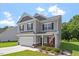 Charming two-story home boasting gray siding, black shutters, and a well-manicured lawn on a sunny day at 534 Lionheart Ln, Sanford, NC 27330