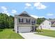 Charming two-story home showcasing gray siding, black shutters, and a well-manicured lawn on a sunny day at 534 Lionheart Ln, Sanford, NC 27330