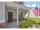 Inviting front porch featuring brick accents, a cozy seating area, and a decorative American flag at 534 Lionheart Ln, Sanford, NC 27330