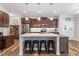 Well-lit kitchen featuring a large island with bar stools, stainless steel appliances, and ample counter space at 534 Lionheart Ln, Sanford, NC 27330