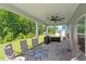 View of the covered patio with ceiling fan and a hot tub overlooking the backyard at 534 Lionheart Ln, Sanford, NC 27330
