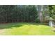 Well-maintained backyard with lush green grass, mature trees, and a classic wooden fence at 55 Fleming Forest Dr, Youngsville, NC 27596