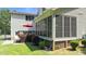 Beautiful backyard with a deck, screened-in porch, lush lawn, and mature trees, perfect for relaxation at 55 Fleming Forest Dr, Youngsville, NC 27596