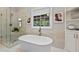 Modern bathroom showcasing a freestanding tub, a glass-enclosed shower, and tile walls at 55 Fleming Forest Dr, Youngsville, NC 27596