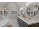 Bright bathroom with double sinks, granite countertops, stylish mirrors, and an adjacent soaking tub at 55 Fleming Forest Dr, Youngsville, NC 27596