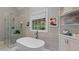 Modern bathroom showcasing a freestanding tub, a glass-enclosed shower, and tile walls at 55 Fleming Forest Dr, Youngsville, NC 27596