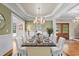 Elegant dining room with hardwood floors, wainscoting, a chandelier, and large windows at 55 Fleming Forest Dr, Youngsville, NC 27596