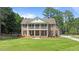Traditional brick home featuring a manicured lawn, a symmetrical facade, and a welcoming front porch at 55 Fleming Forest Dr, Youngsville, NC 27596